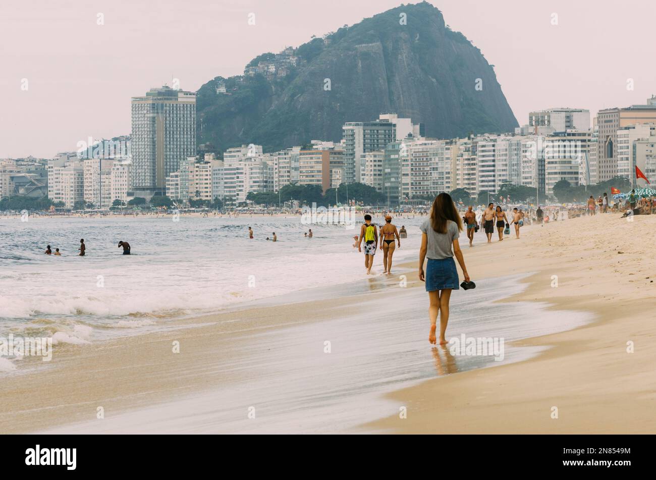 Rio de Janeiro, Brazil - February 7, 2023: People at Copacabana beach in Rio de Janeiro, Brazil on a cloudy day Stock Photo