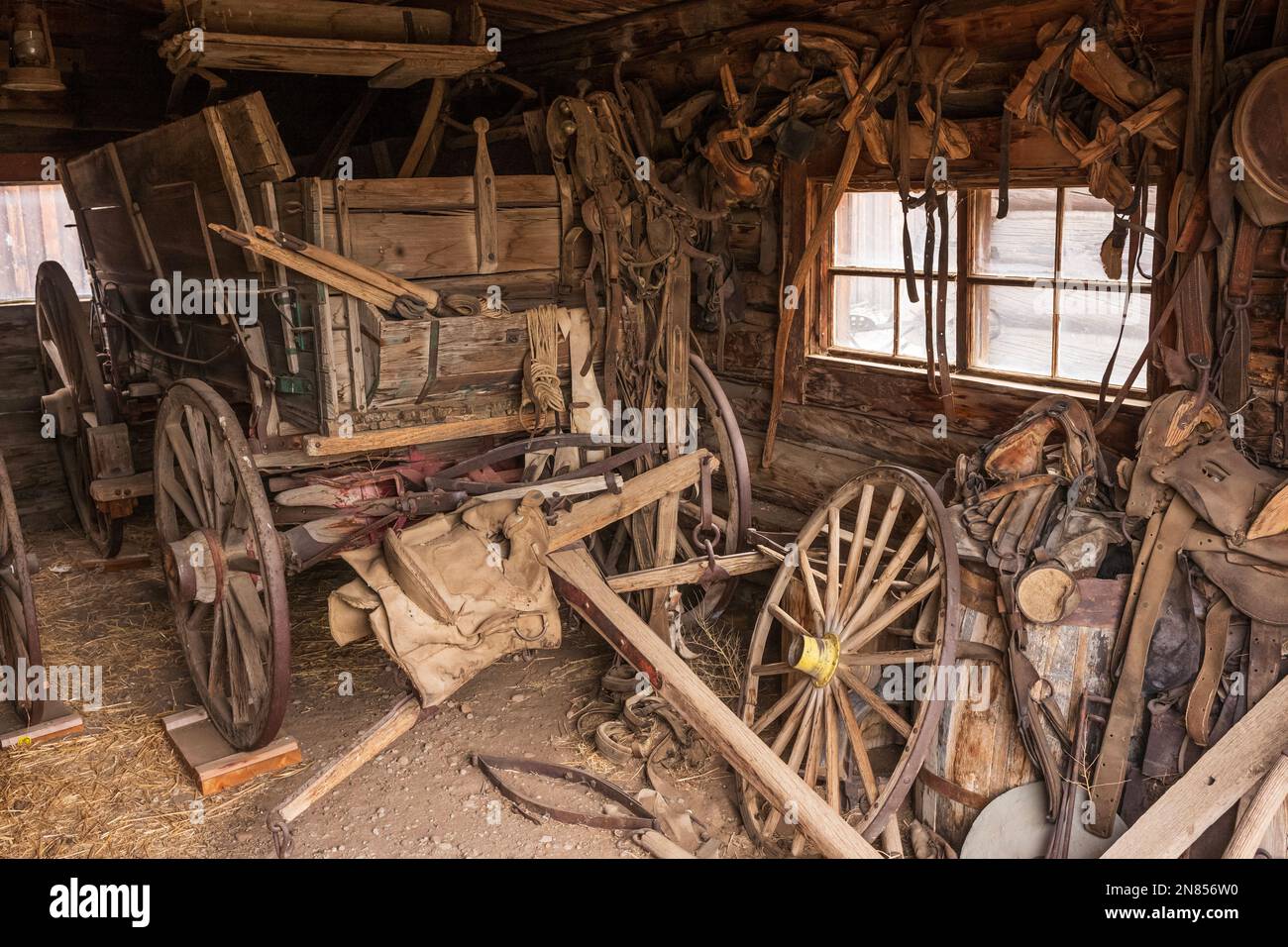 Cody, WY, USA - Jun 25, 2022: Old Trail Town is a tourist attraction with authentic frontier buildings from the late 1800's.  A garage with old wagon Stock Photo