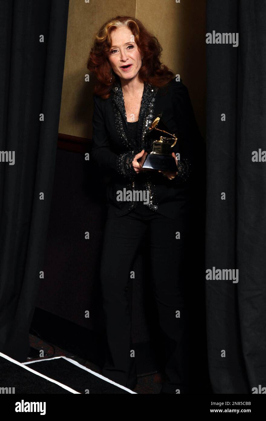 Bonnie Raitt poses backstage with the award for best americana album