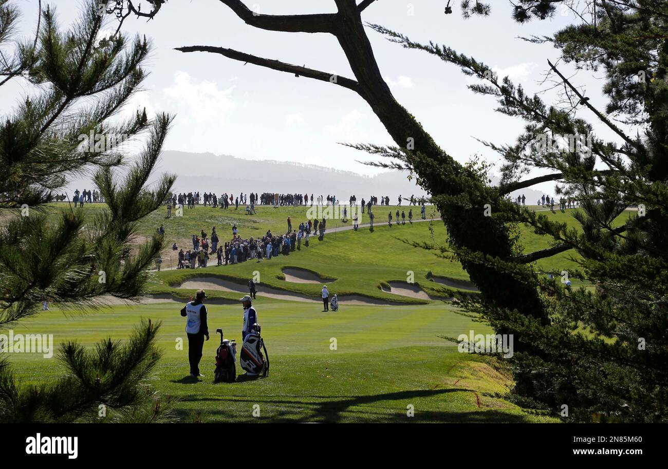 Caddies wait on the sixth fairway of the Pebble Beach Golf Links during