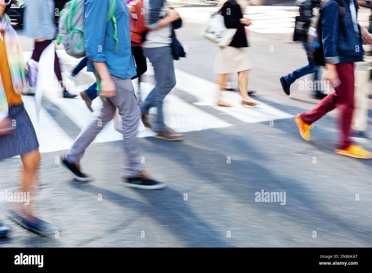 picture with motion blur of crowds of people who crossing a city street ...