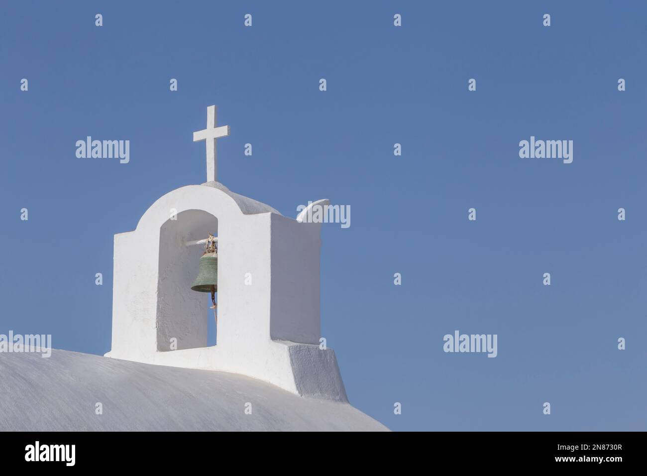 bell tower on chapel on Santorini island in Greece against clear blue sky Stock Photo