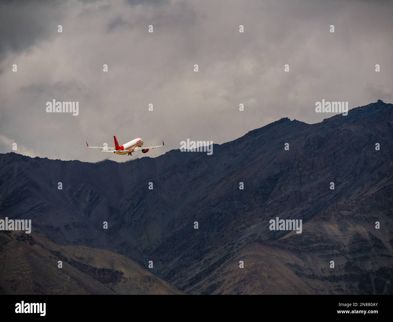 Ladakh, India - June 19, 2022 : Air India indian passenger plane fly up from Leh airport surrounded by Himalaya mountain range Stock Photo