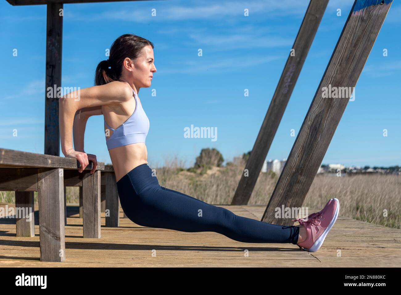 Sporty woman doing reverse push ups outside on a wooden bench Stock Photo Alamy