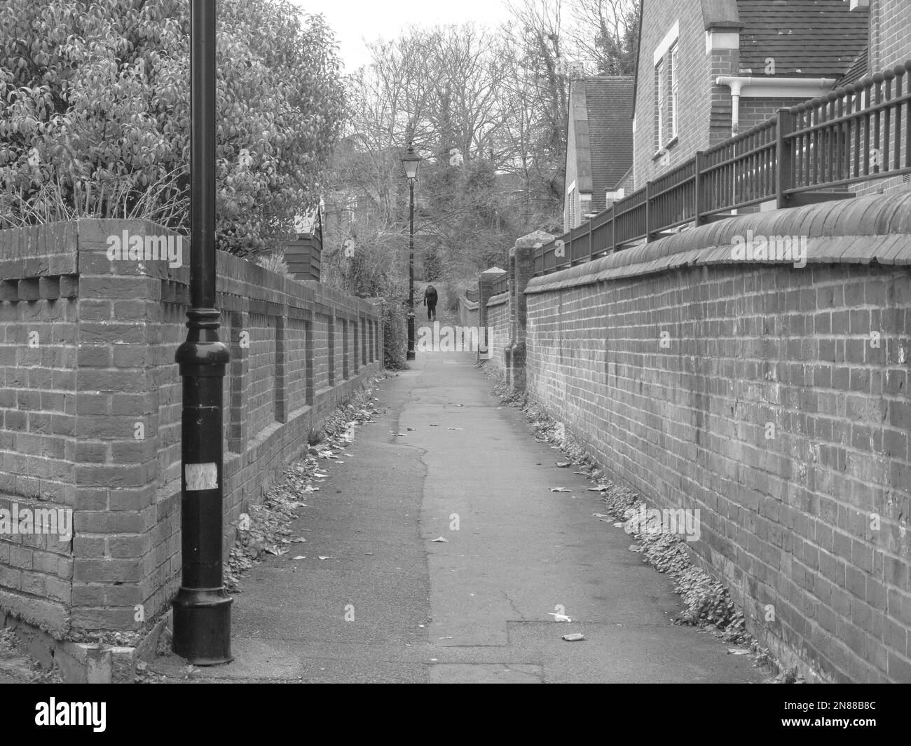 A grayscale of a narrow alley, and old brick walls, in Fareham UK Stock