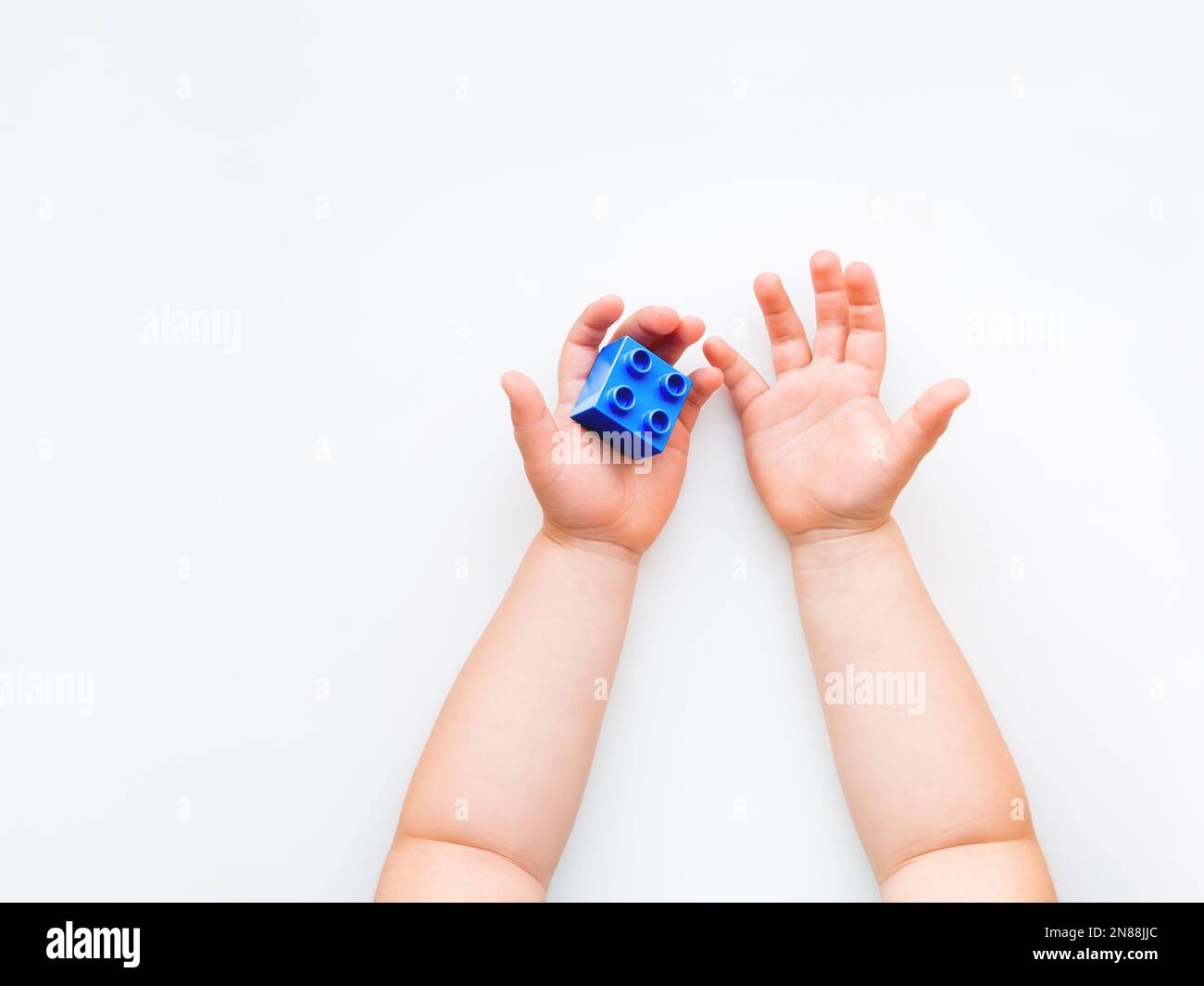 Fists Making Blocks Child is holidng a blue constructor block in fist. Kid's hands with toy ...