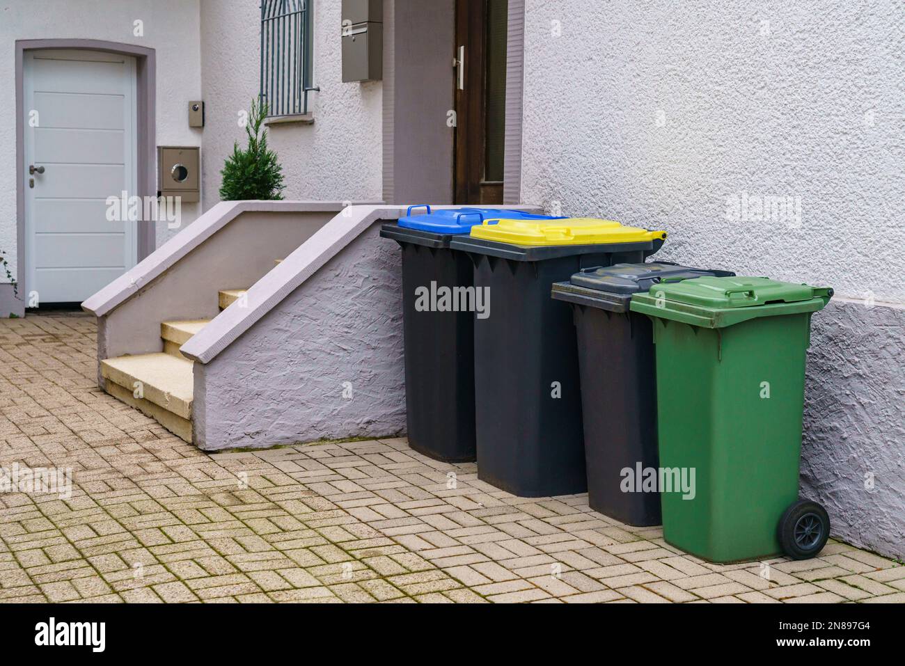 Plastic multicolored trash cans for garbage near the entrance to a
