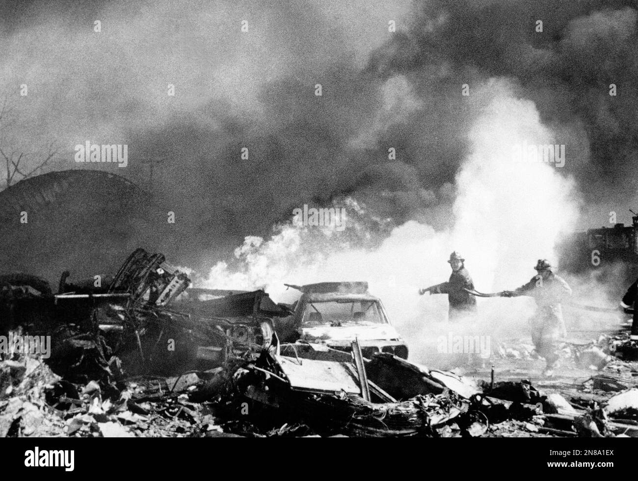 Firemen pour water on flaming wreckage of American Airlines Flight 191 ...