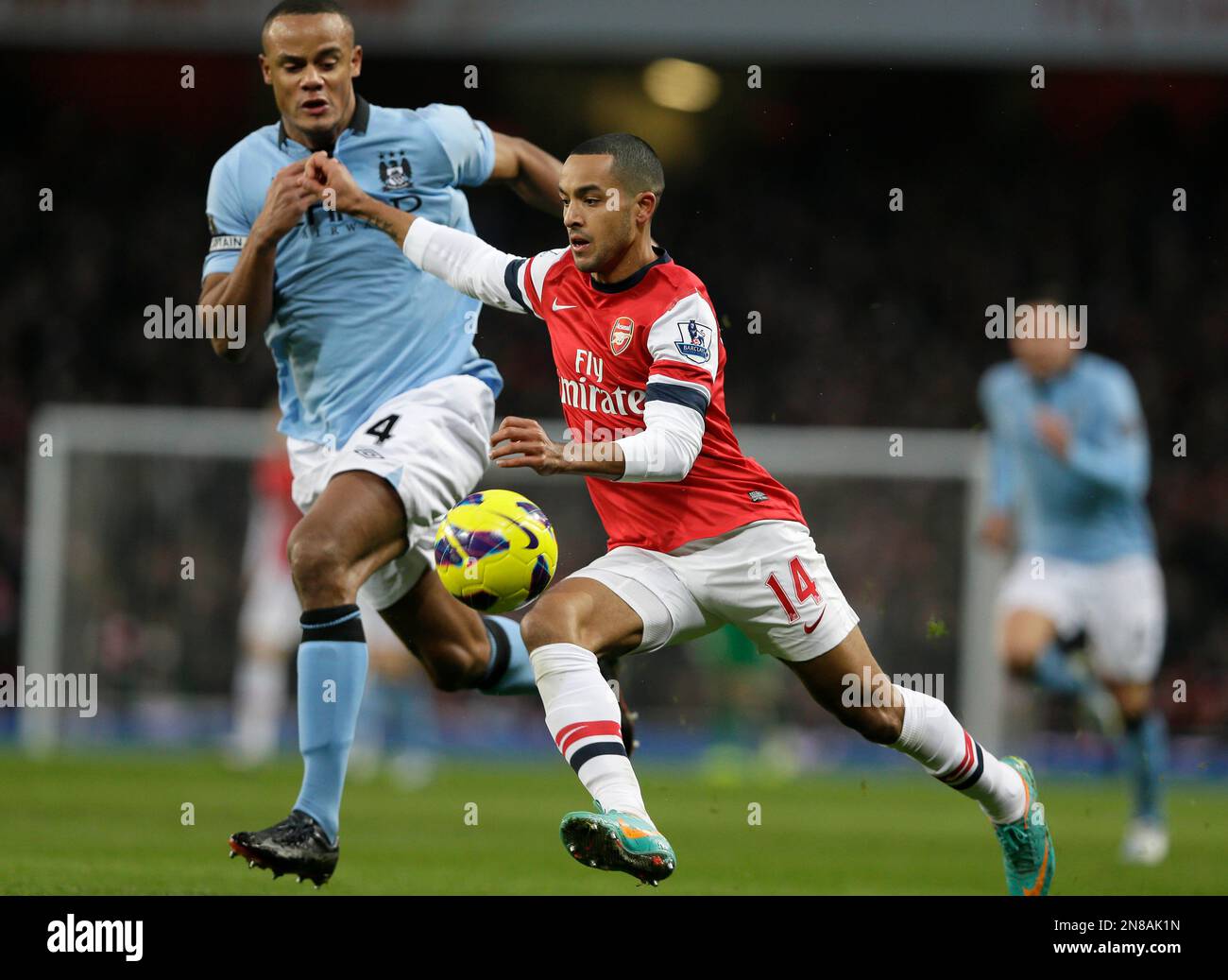 Arsenal's Theo Walcott, right, takes the ball past Manchester City