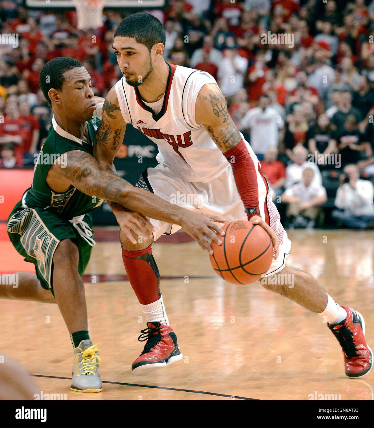 South Florida's Anthony Collins, Left, attempts to steal the ball from  Louisville's Peyton Siva during the second half of an NCAA college  basketball game Saturday Jan. 12, 2013, in Louisville, Ky. Louisville