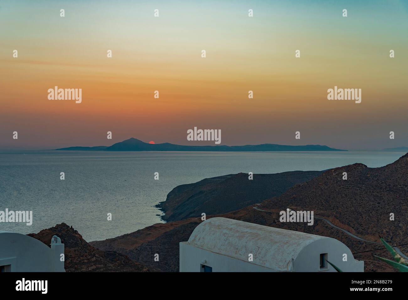 Sun setting over Santorini seen from the nearby island of Anafi Stock Photo