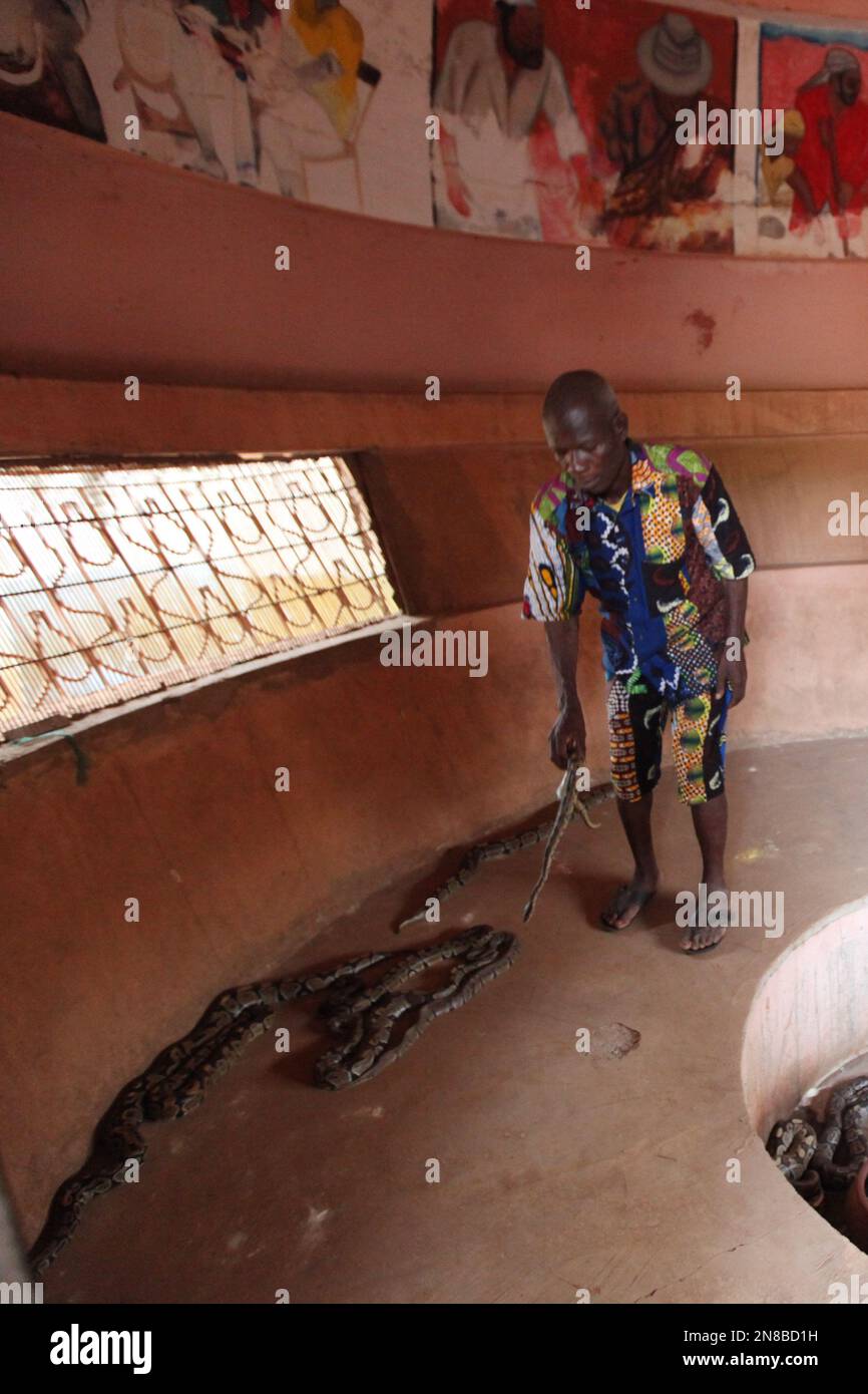 Jean Zossoujbo, a guide at the Temple of Pythons, shows a python to a ...