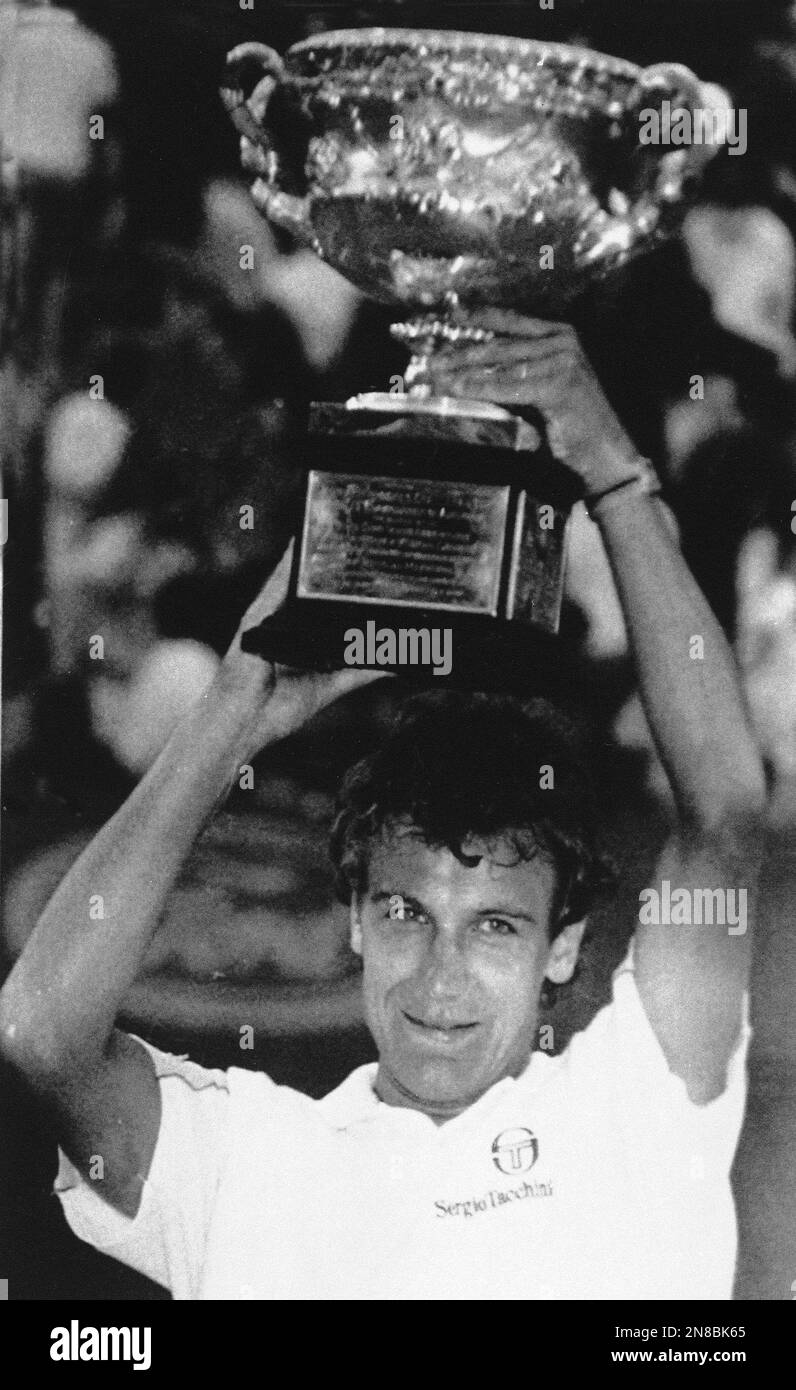 The Swedish tennis star Mats Wilander holds the trophy aloft after he