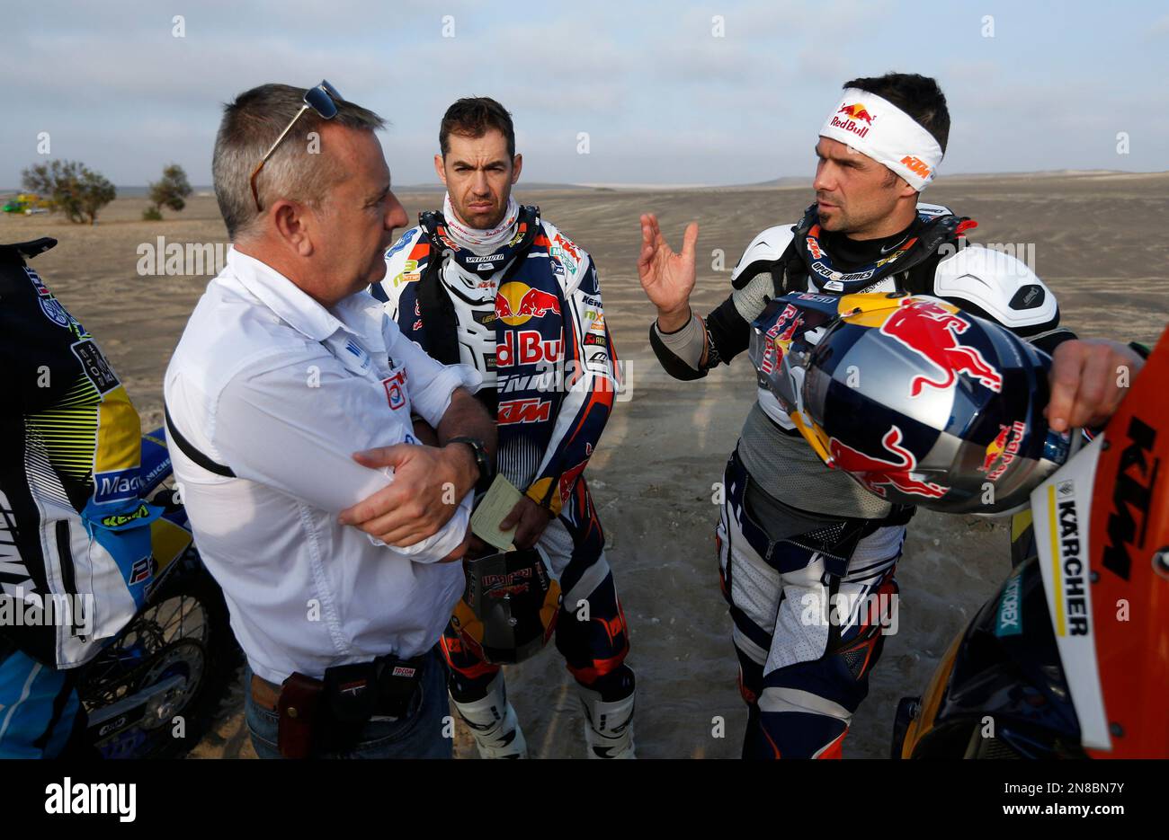 Dakar rally director Etienne Lavigne, left, talks to KTM rider Cyril Despres  of France, right, as KTM rider Ruben Faria of Portugal, center, looks on  before the start of the 3nd stage, image size:1300x935
