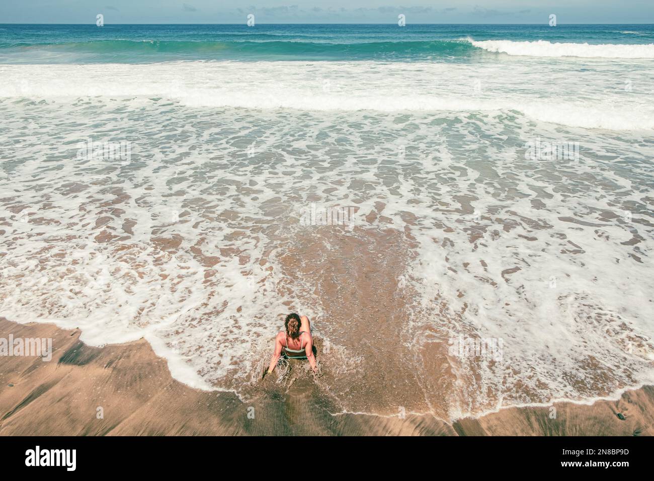 Young girl enjoying the waves on Vigocho beach, spectacular setting Stock Photo