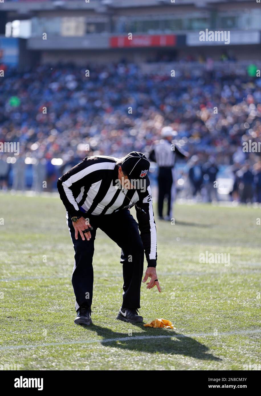 Head Linesman Tom Stabile picks up a flag in the first quarter of