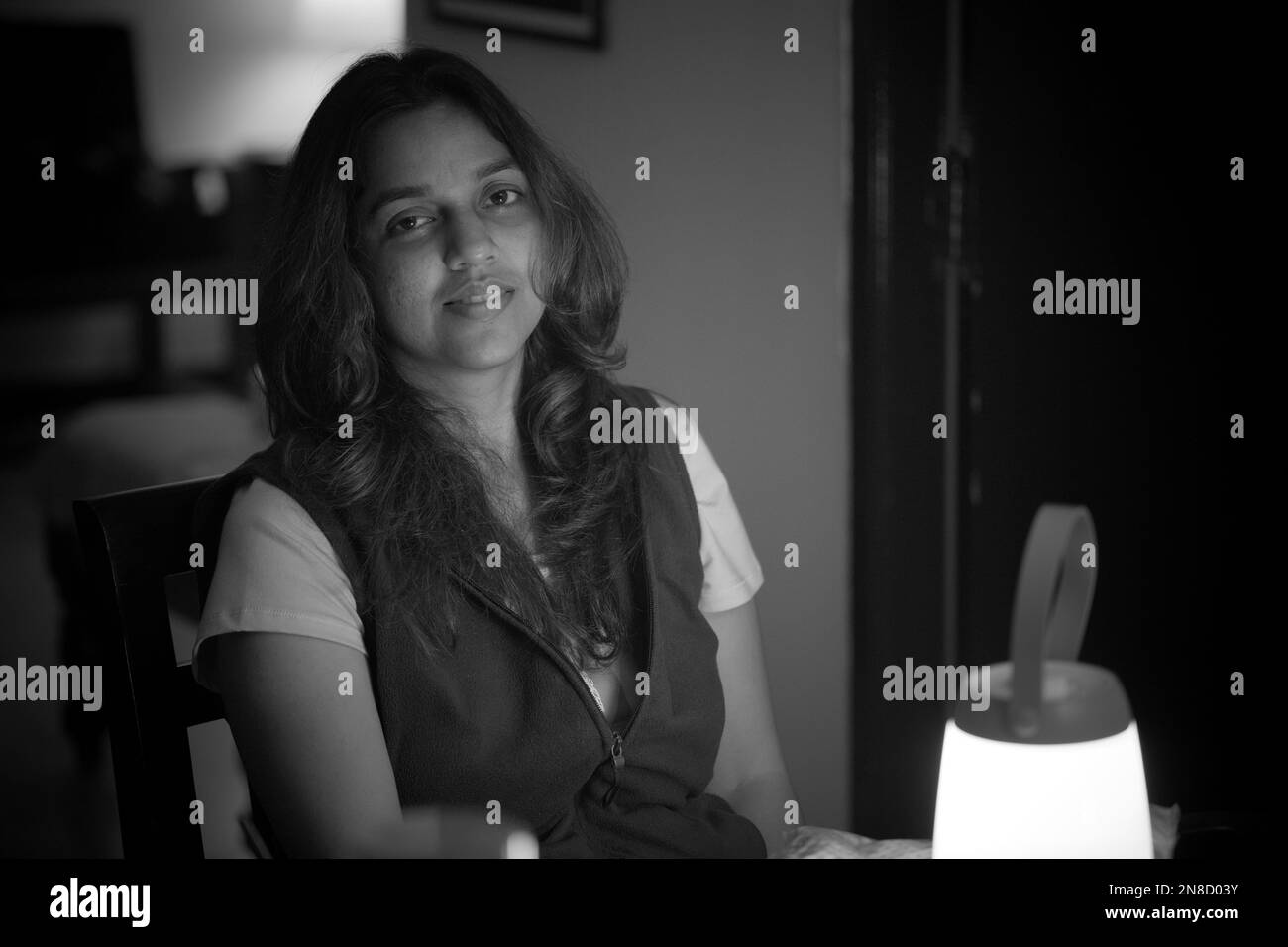 A black and white portrait of a beautiful Indian girl sitting in a room ...