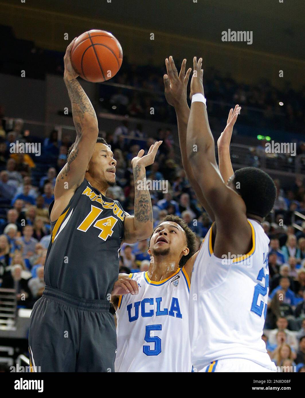 Missouri's Negus Webster-Chan, left, passes the ball as he is defended by UCLA's Tony Parker, right, and Kyle Anderson during the first half of an NCAA college basketball game in Los Angeles, Friday, Dec. 28, 2012. (AP Photo/Jae C. Hong) Stock Photo
