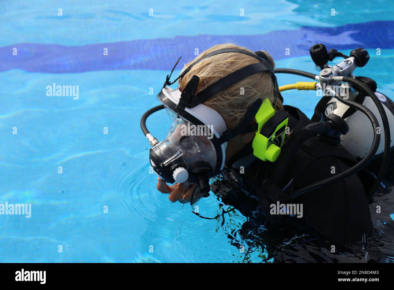 May 24, 2017 - Tuscany, Italy: A woman wear a full face diving mask with ear comm ready for the training in the pool. Full Face diving mask training Stock Photo