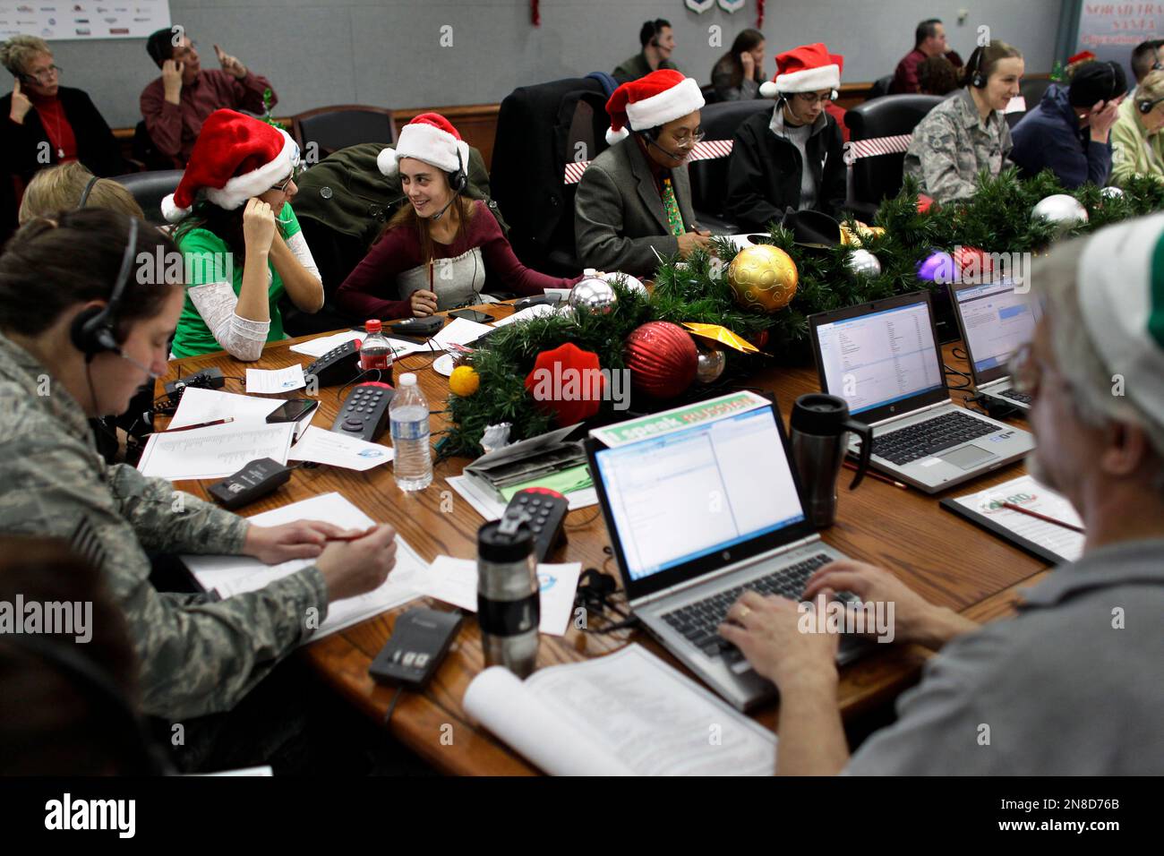 Lizzie Solano, center, and her sister Sarah take phone calls from children asking where Santa is and when he will deliver presents to their house, during the fifth annual NORAD Tracks Santa Operation, at the North American Aerospace Defense Command, or NORAD, at Peterson Air Force Base, in Colorado Springs, Colo., Monday Dec. 24, 2012. Over a thousand volunteers at NORAD handle more than 100,000 thousand phone calls from children around the world every Christmas Eve, when NORAD continually projects Santa Claus's supposed progress delivering presents. (AP Photo/Brennan Linsley) Stock Photo