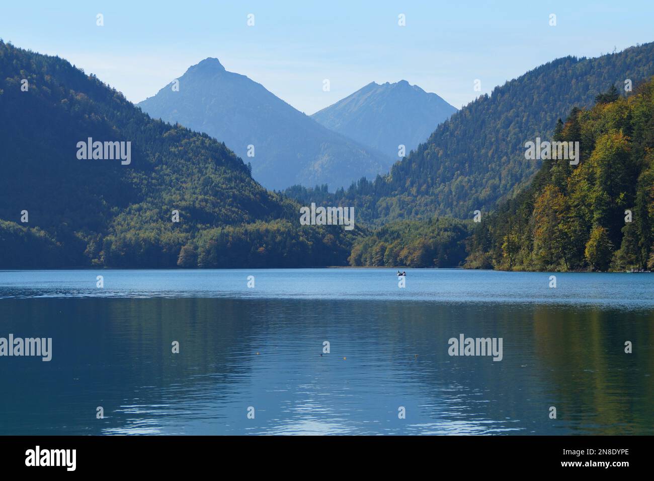 gorgeous calm emerald-green alpine lake Alpsee in the Bavarian Alps on a sunny day with the blue sky in the village Hohenschwangau, Bavaria, Germany Stock Photo