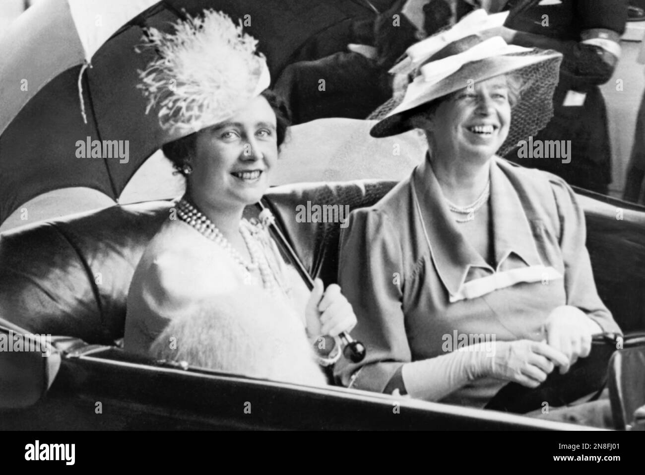Eleanor Roosevelt and Queen Elizabeth, holding umbrella, in an automobile leaving Union Station for the White House on June 8, 1939, during the Royal Visit to the United States by Great Britain's King George VI and the Queen Consort. Stock Photo