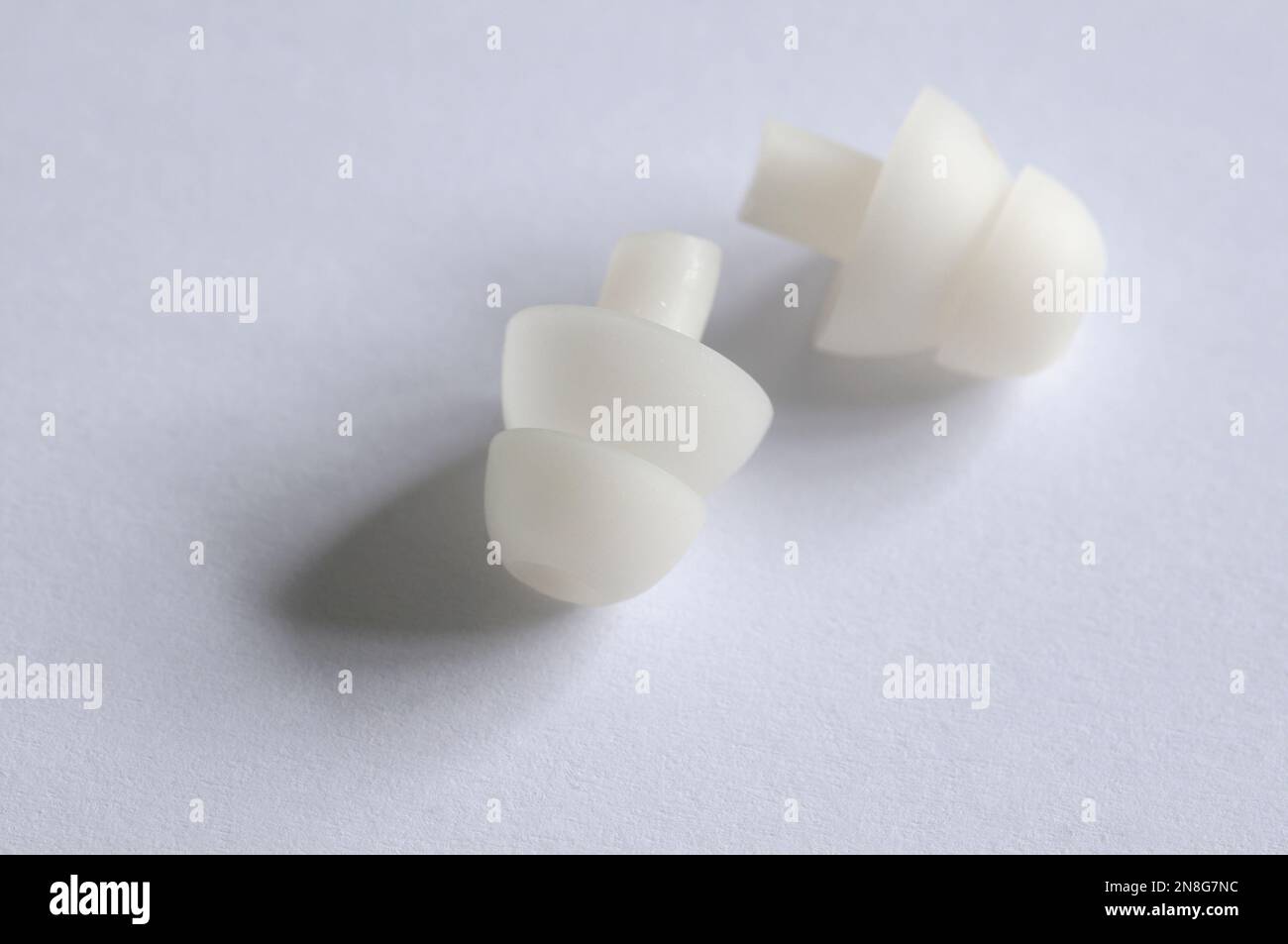 Close-up of reusable earplugs or ear plugs for noise reduction and hearing protection. Selective focus on a white background Stock Photo