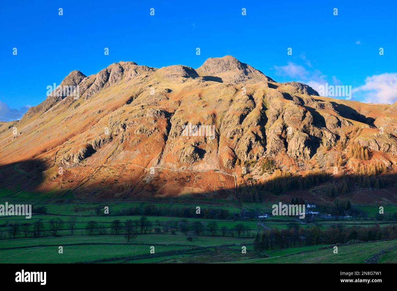 Sunlight on mountain peaks of The Langdale Pikes, rugged mountainous