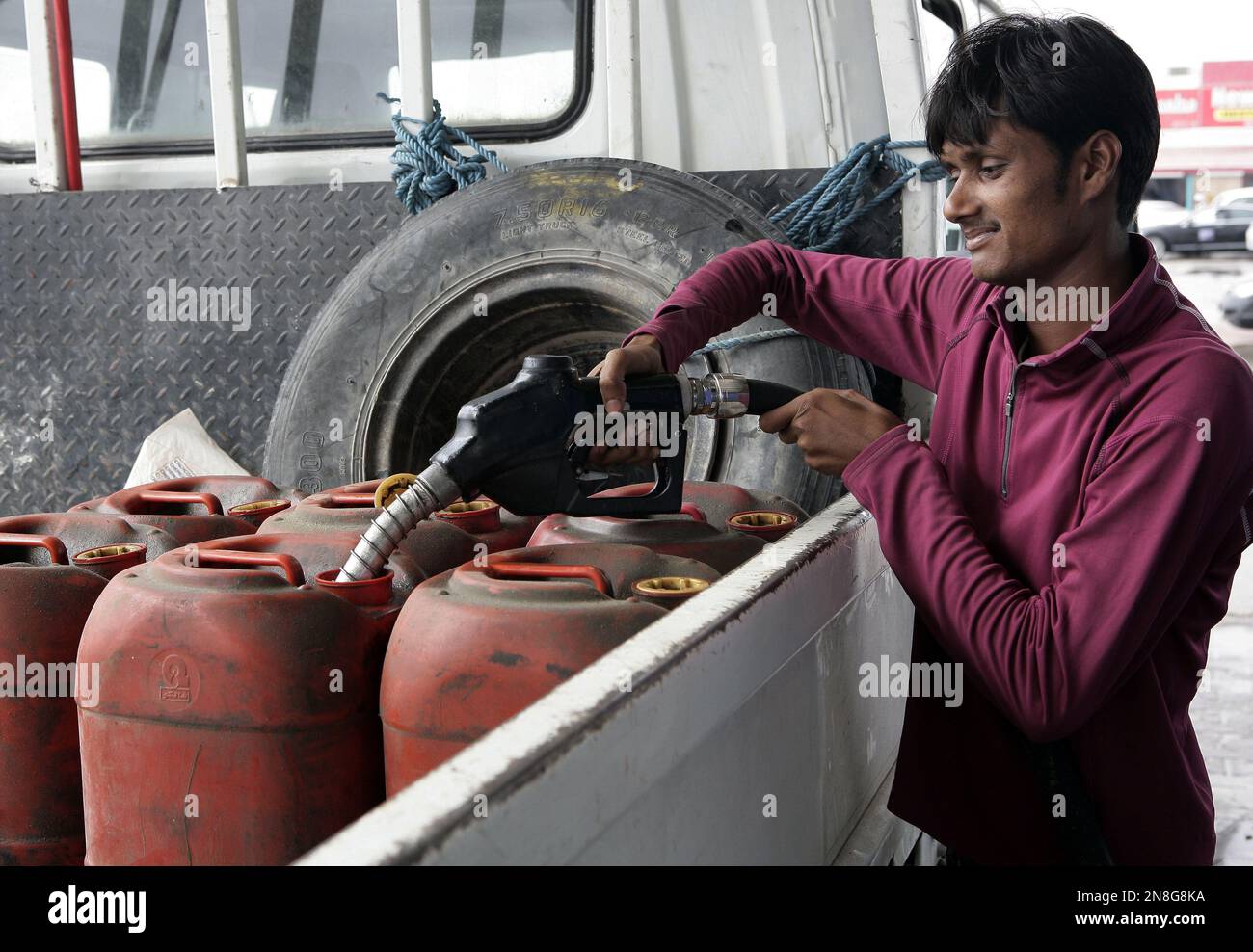 In this Saturday, Dec. 1, 2012 photo, a man fills gasoline in plastic