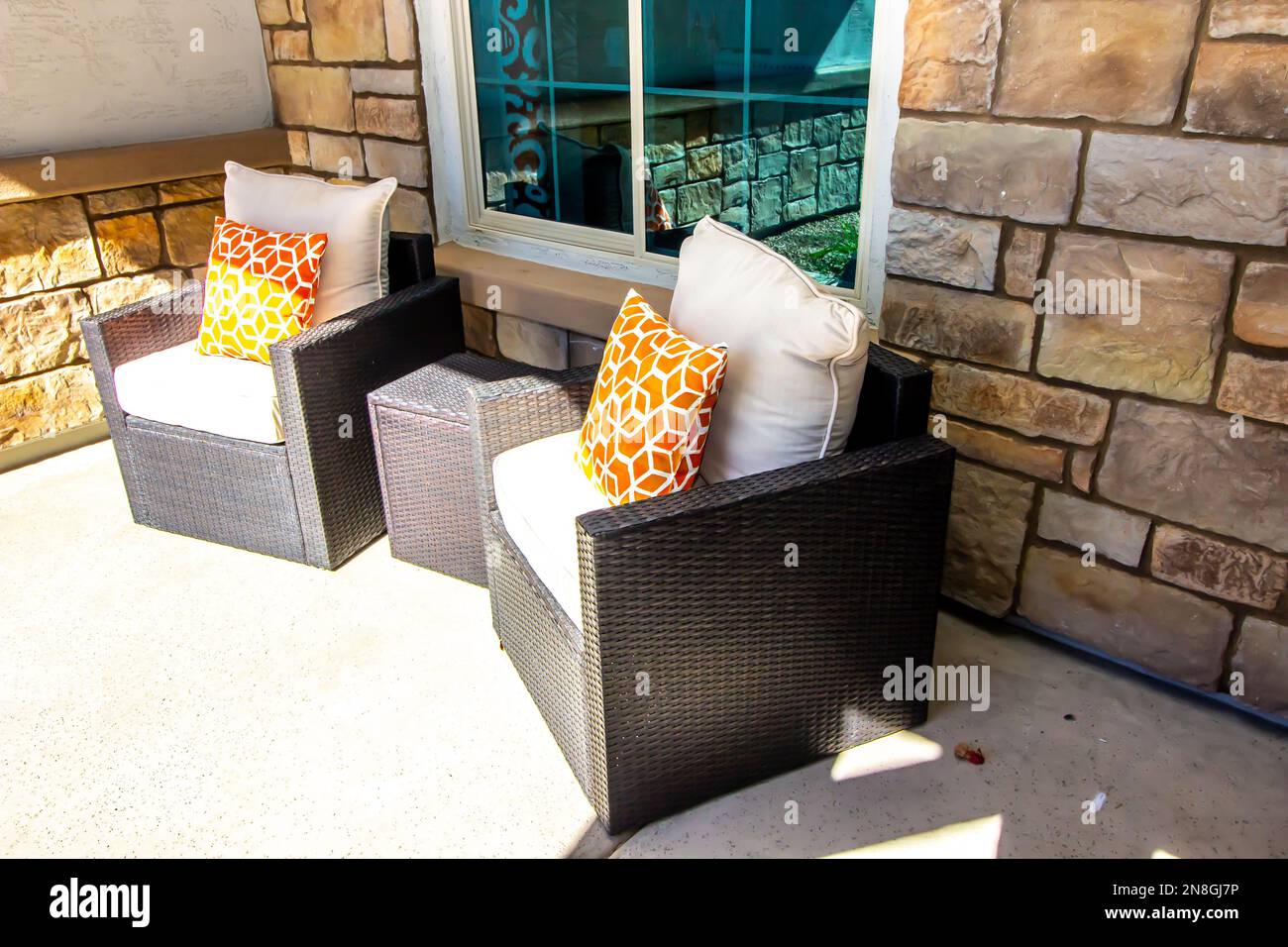 Two Wicker Arm Chairs On Front Patio Stock Photo