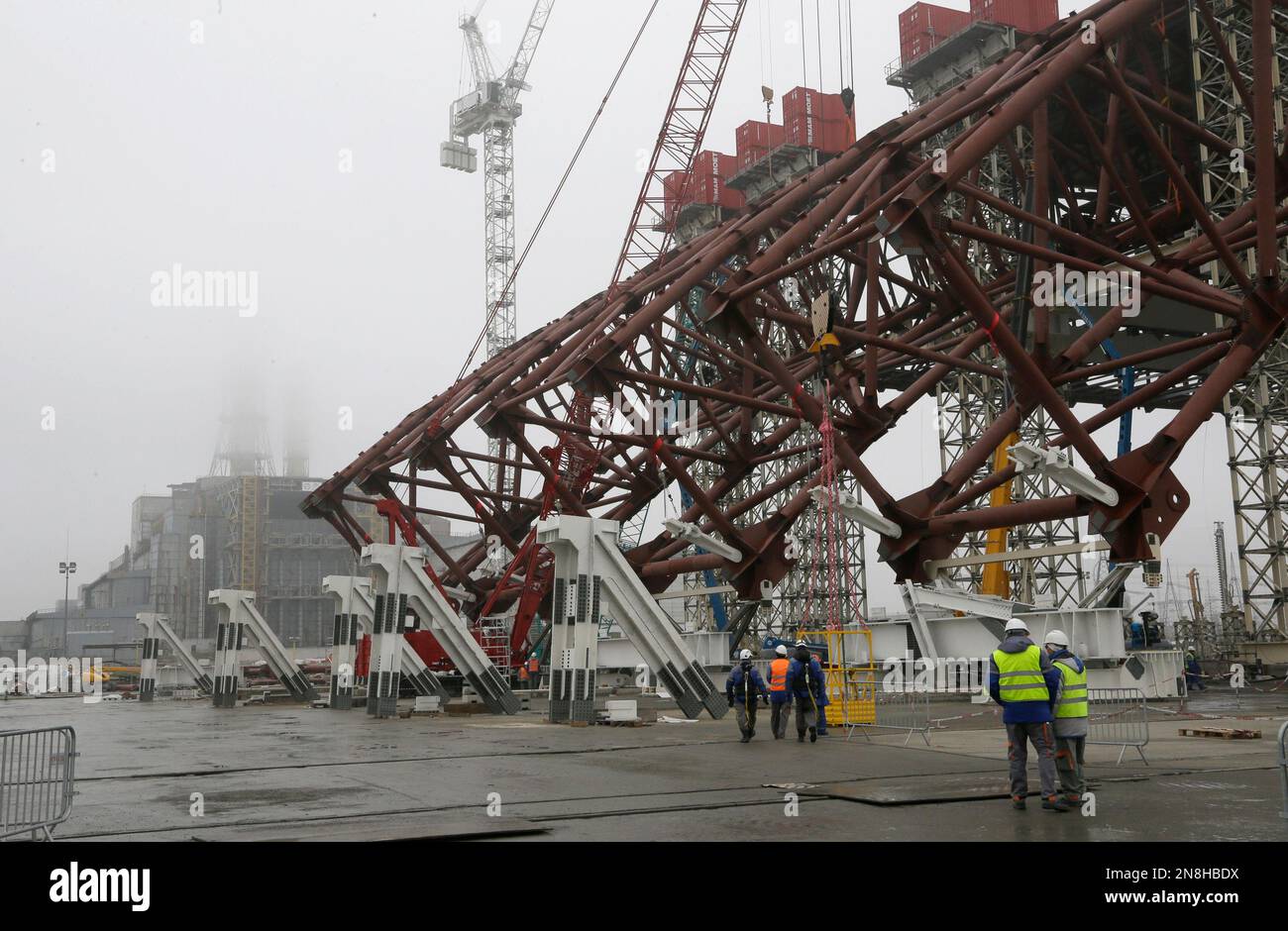 Construction workers assist in the assembly of a gigantic steel-arch to ...