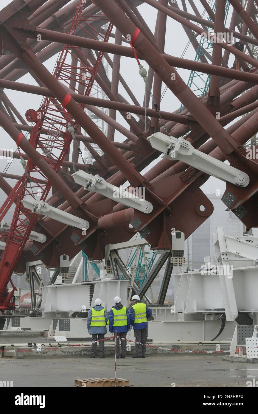 Construction workers assist in the assembly of a gigantic steel-arch to ...
