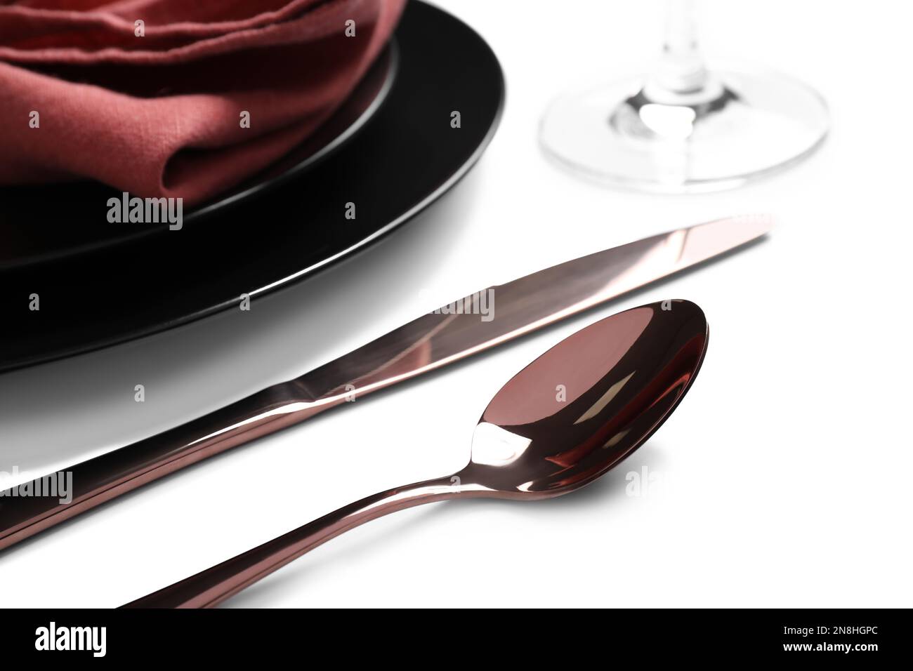 Elegant shiny cutlery near plates on white background, closeup Stock