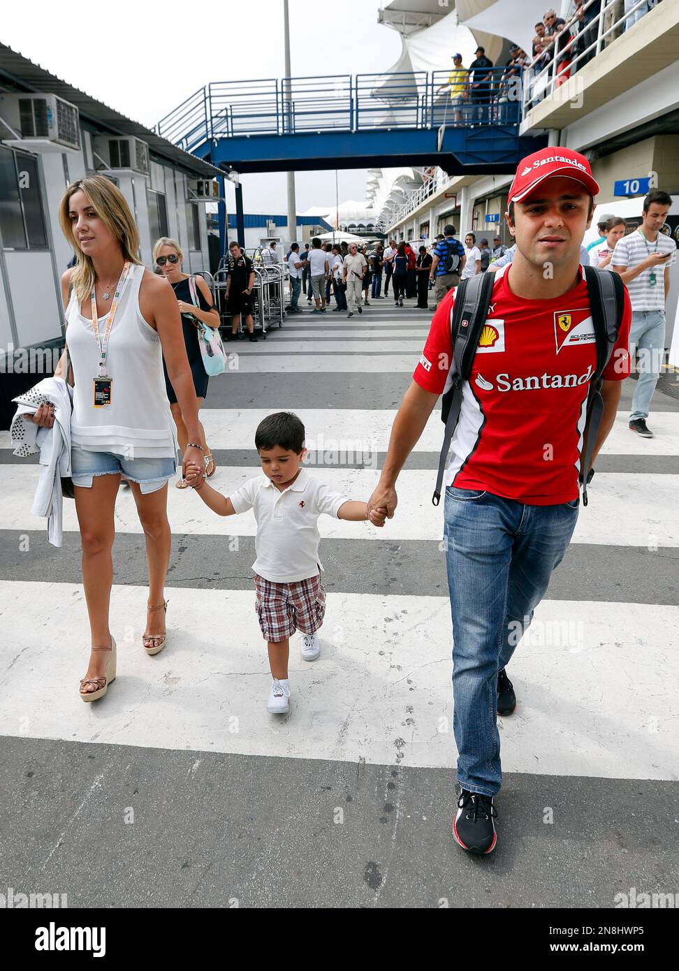 Ferrari driver Felipe Massa of Brazil, right, walks on paddock with his ...