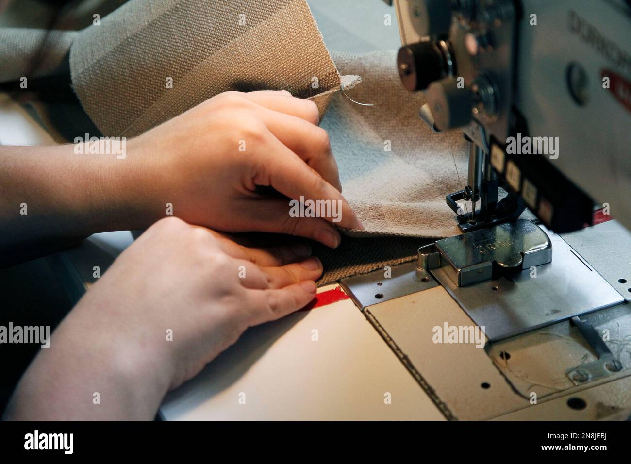 In this Oct. 25, 2012 photo, an employee carefully stitches sections of