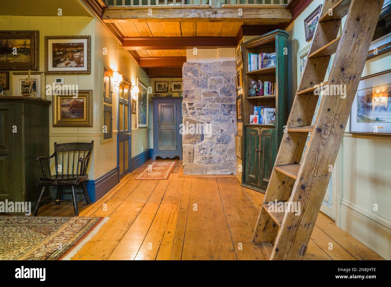 Hallway with wide pinewood floorboards, Miller's stairs, bookcase and