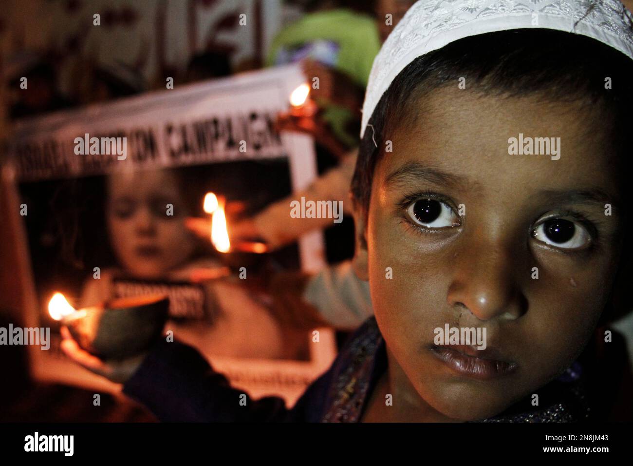 Pakistani students light candles to condemn the Israeli offensive in