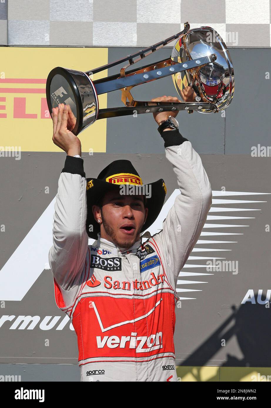 McLaren Mercedes driver Lewis Hamilton of Britain holds the trophy