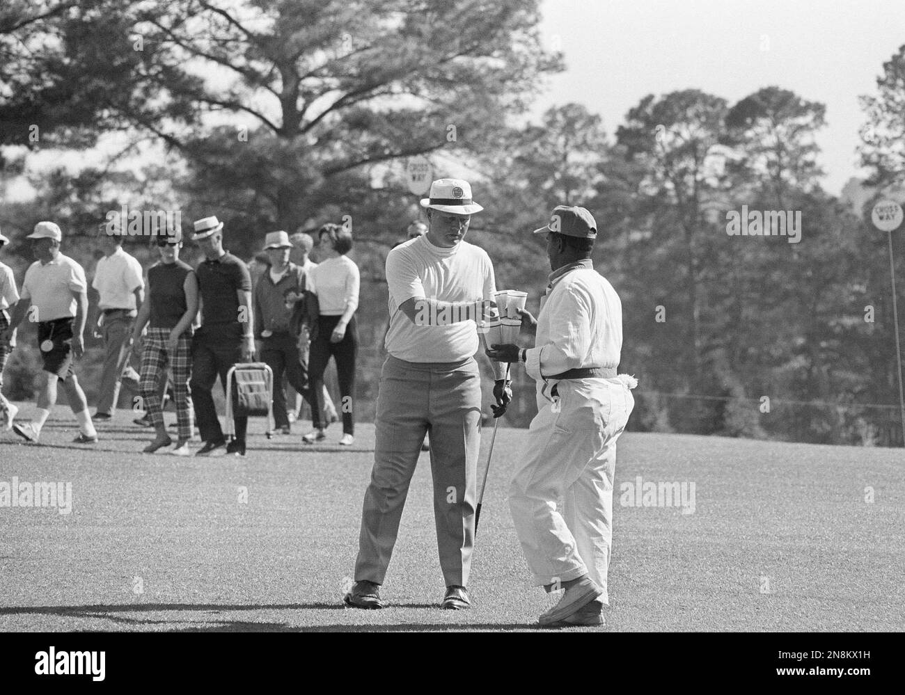 Jack Nicklaus reaches out for a cold drink held by his caddy as he took
