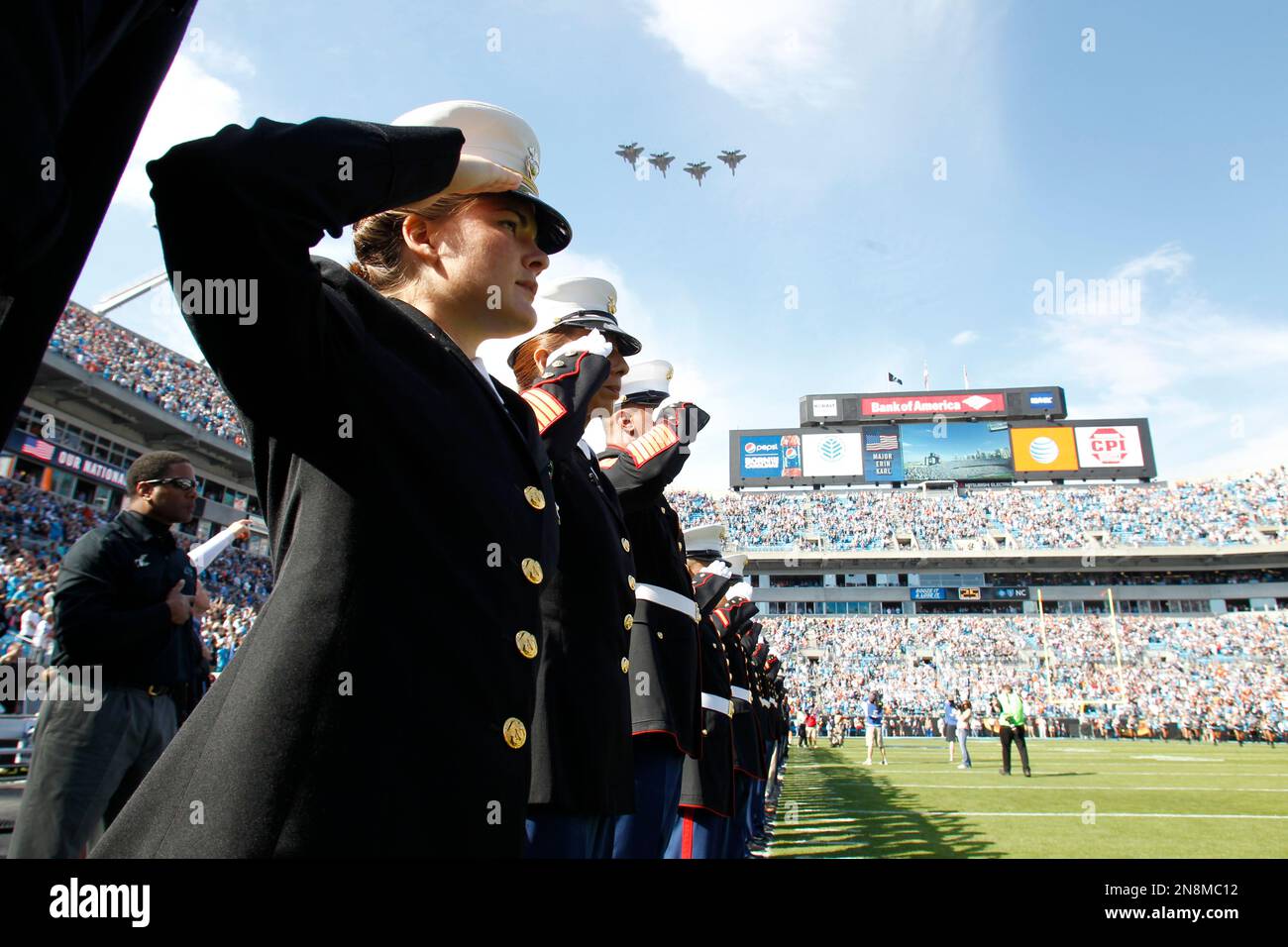 Members of the military salute during the national anthem as part 