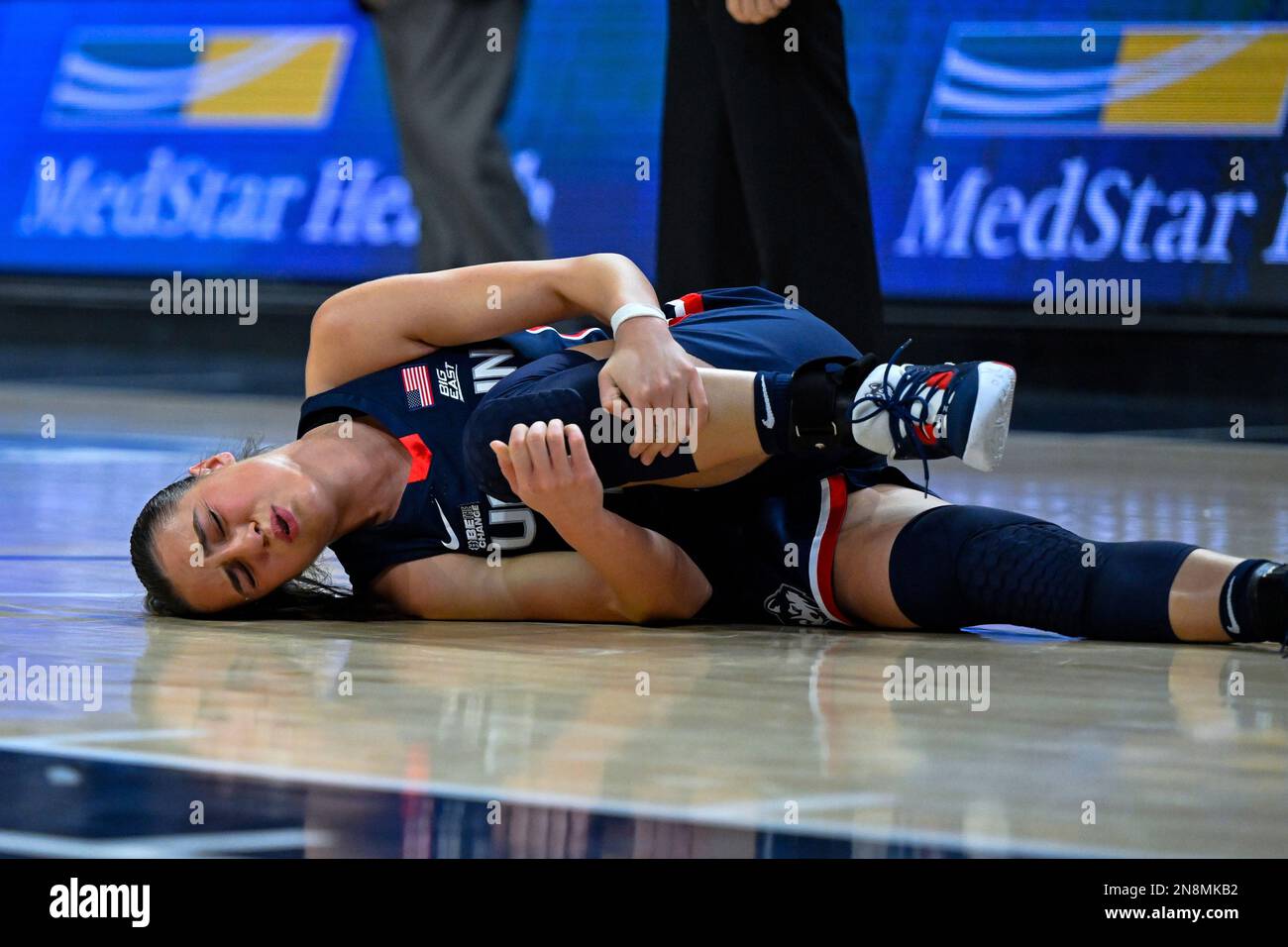 UConn guard Nika Muhl holds her legs after injuring her ankle during the  second half of an NCAA college basketball game against Georgetown,  Saturday, Feb. 11, 2023, in Washington. (AP PhotoTerrance Williams