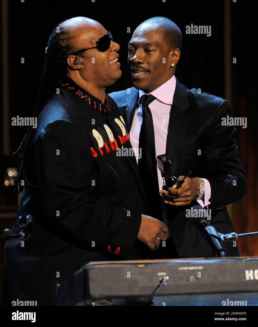 Stevie Wonder, left, is embraced by Eddie Murphy after they performed