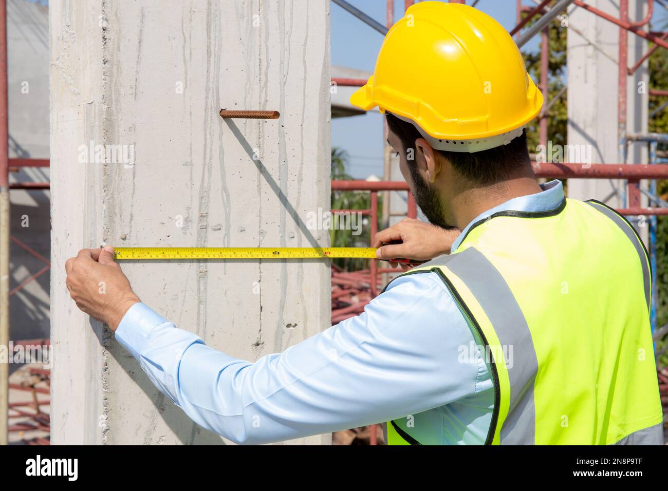 Engineer young man using tape measure for check and examining length of structure with professional at construction site architect inspection and imp
