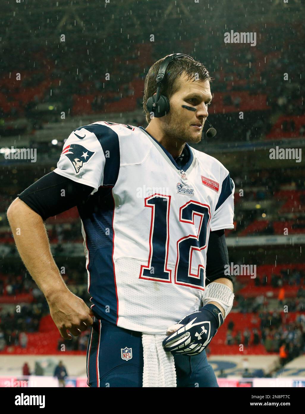 New England Patriots quarterback Tom Brady, talks as rain falls during the second half of a NFL