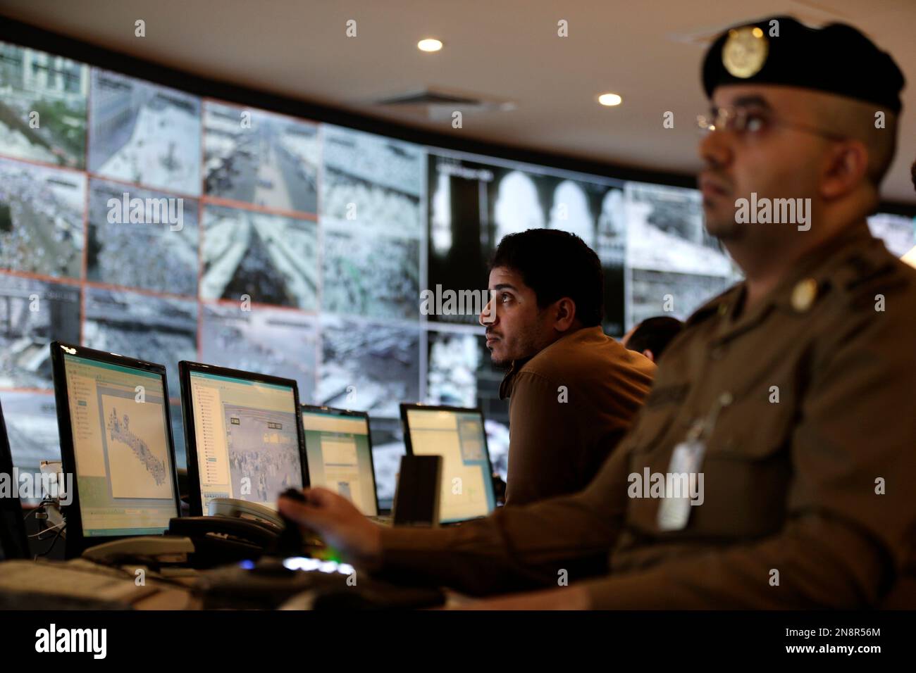 Saudi police officers monitor screens connected to cameras set up to monitor the huge crowds