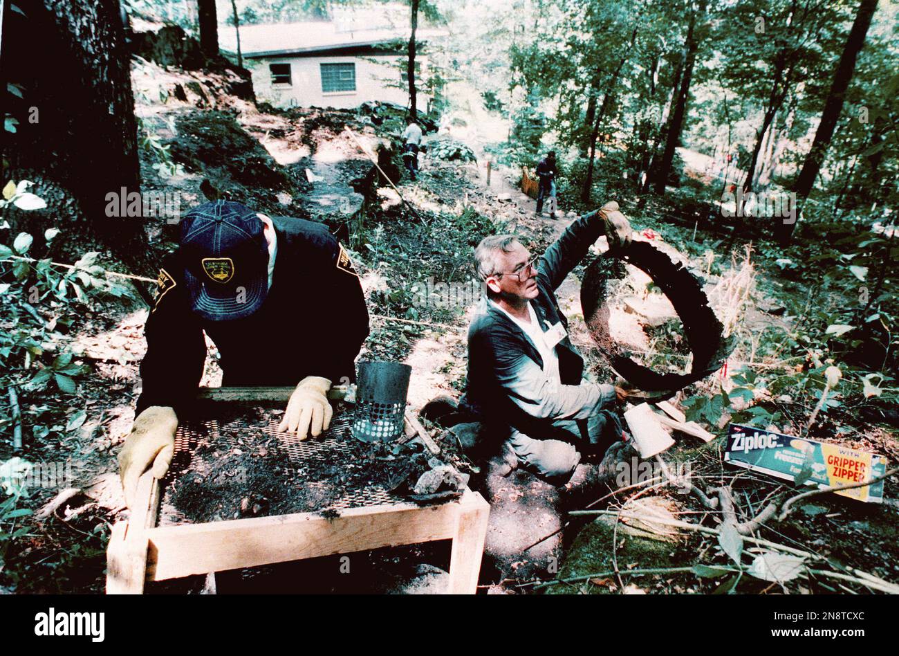 Summit County sherrif's detective Larry Momchilov sifts through debris ...