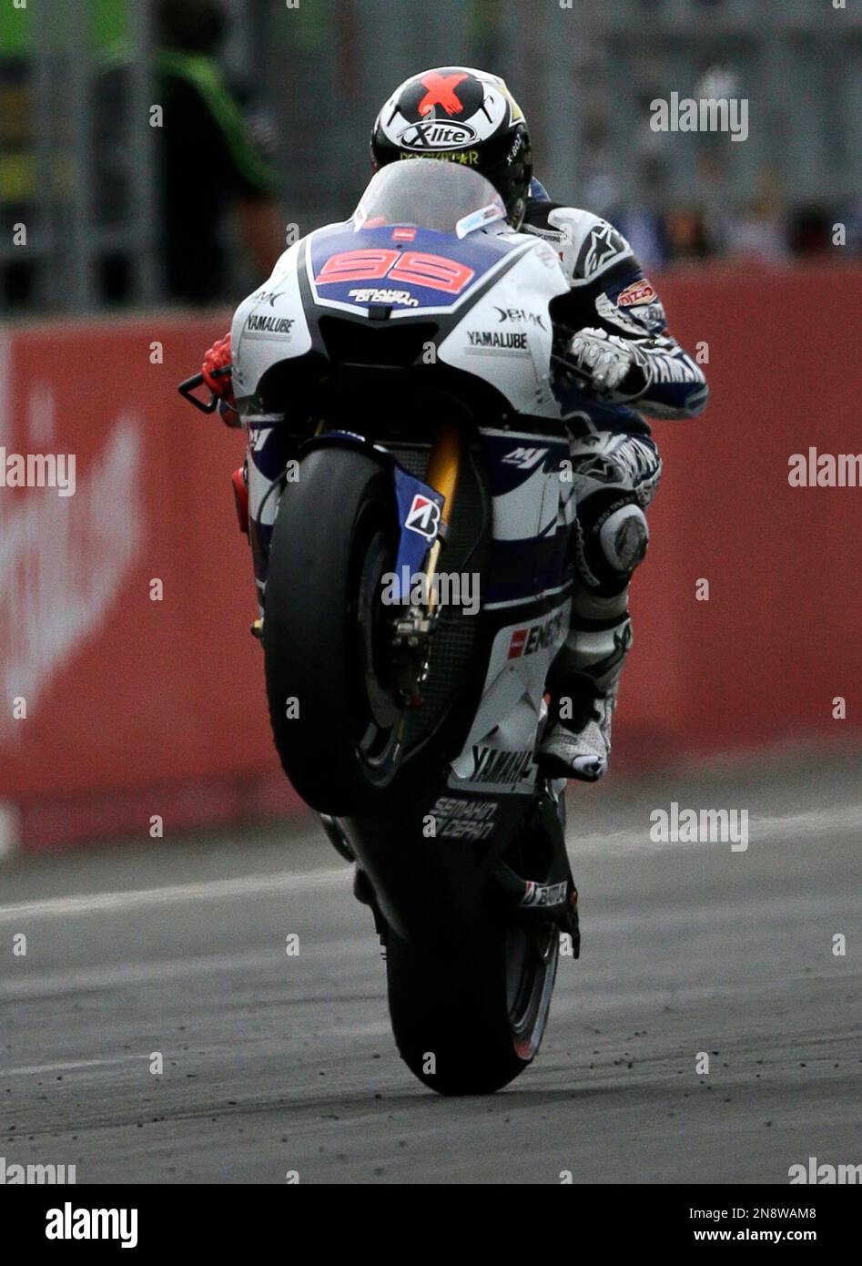 Spain's Jorge Lorenzo does wheelie as he crosses the finish line to