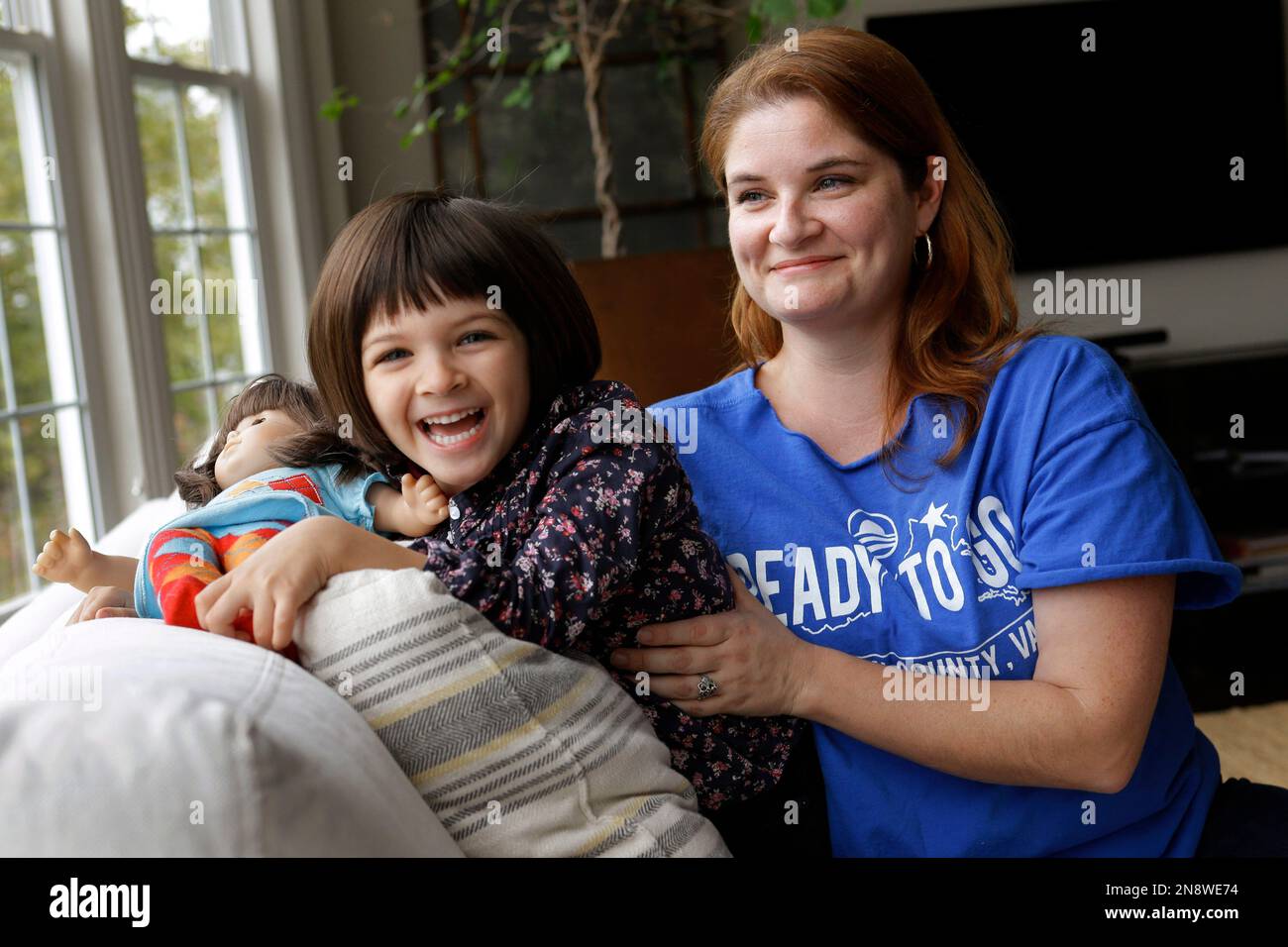 In this Monday, Oct. 8, 2012 photo, Molly Lovato, a volunteer with the Obama campaign, poses for a photograph with her daughter Nola Trindade, 4, at their home in Leesburg, Va. Lovato credits the president with steering the country away from financial disaster. "I think he kept us from sliding into a depression," she says. "I'm really dumbfounded by people who say 'Why didn't he fix this?' and it's 20 minutes later." She compares reviving the economy to gutting and then rehabbing a home. "It takes a hot minute for everything to unravel," she says, "but to put it back together is really very di Stock Photo