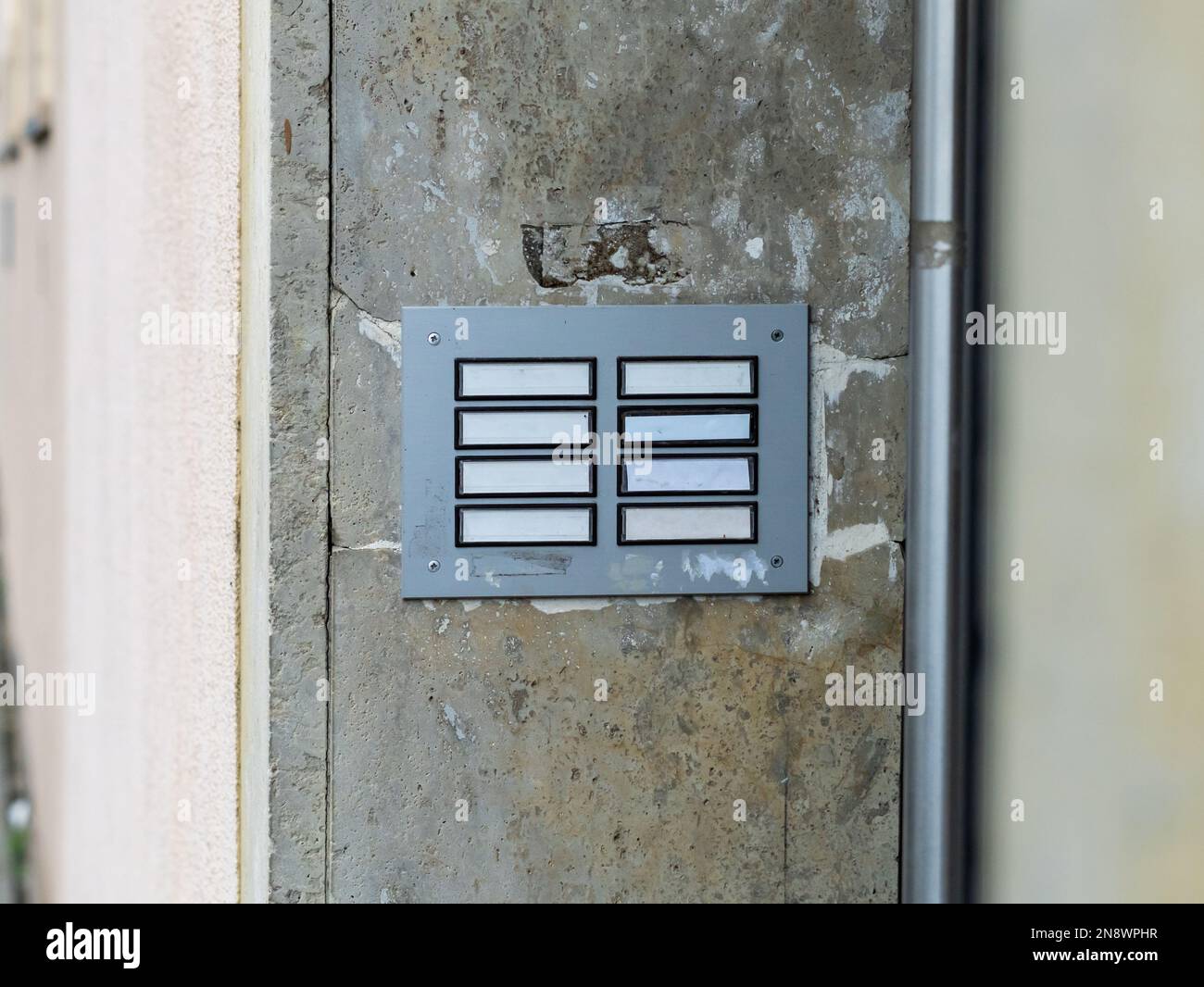 Empty name panel at an apartment building. Blank template for names at a doorbell panel. Residential house with government flats. Filthy old knobs. Stock Photo