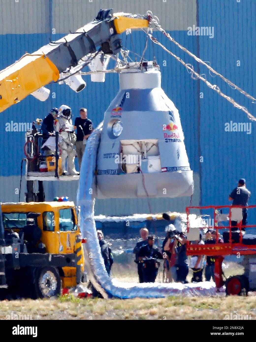 Felix Baumgartner, in pressurized suit on platform at left, prepares to enter the balloon capsule in Roswell, N.M. on Tuesday, Oct. 9, 2012. Baumgartner will attempt to break the speed of sound with his own body by jumping from the space capsule lifted by a 30 million cubic foot helium balloon. Baumgartner plans to jump from an altitude of 120,000 feet - an altitude chosen to enable him to achieve Mach 1 in freefall - which will deliver scientific data to the aerospace community about human survival from high altitudes. (AP Photo/Matt York) Stock Photo